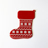 Red and white Christmas stocking with snowflake pattern on a white background with braille text.