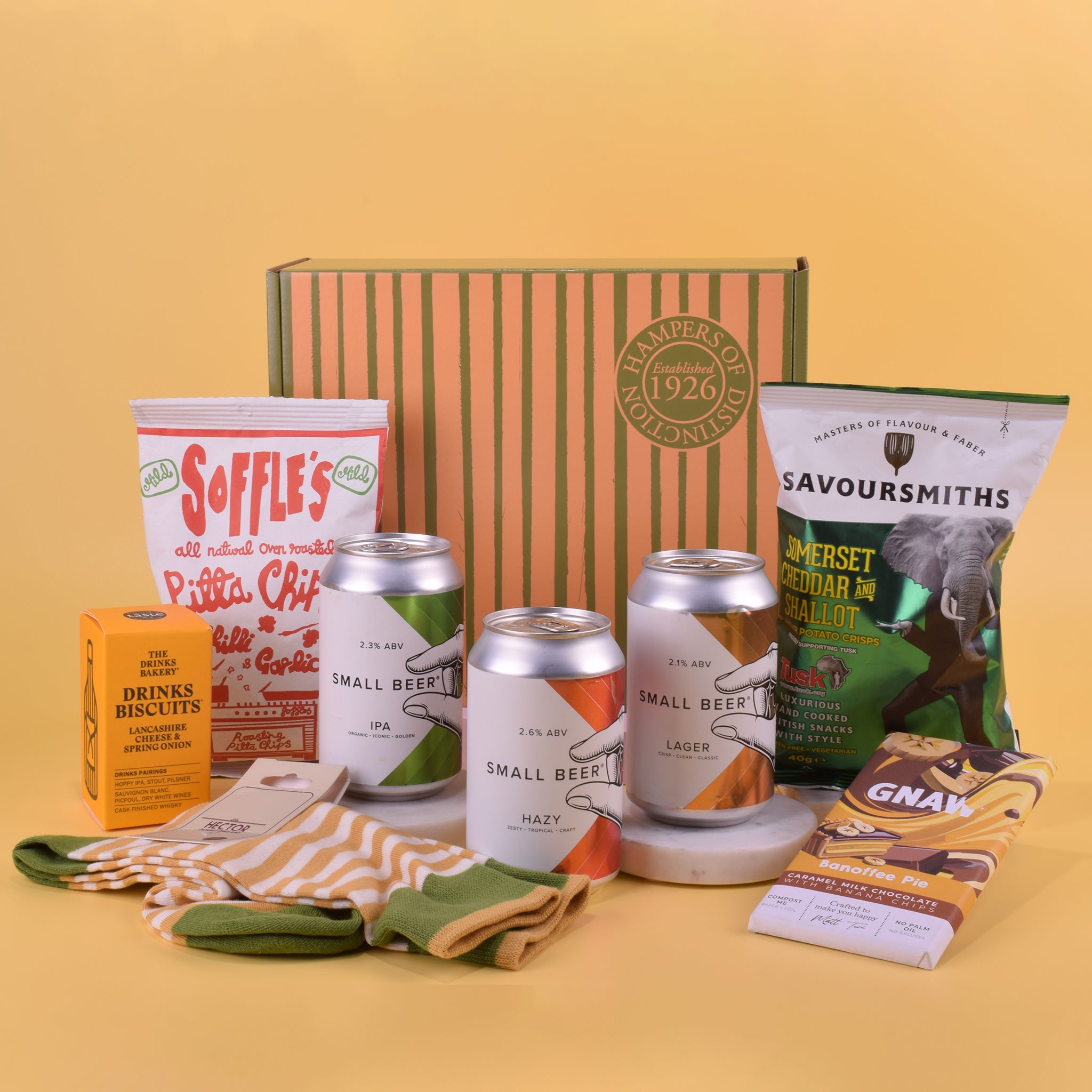 Collection of beer, snacks, and a box on a yellow background