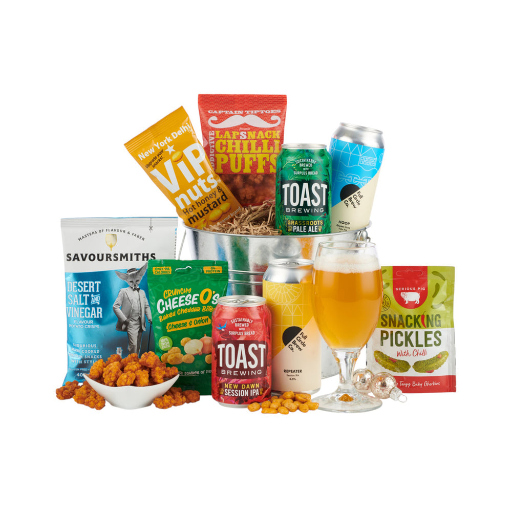 Assorted snacks and drinks including beer , crisps, and pickles in a silver bucket.