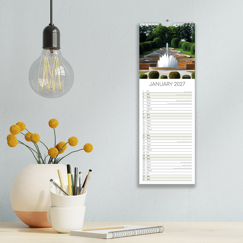 Calendar for January 2027 on a wall next to decorative items including a light bulb and flowers.