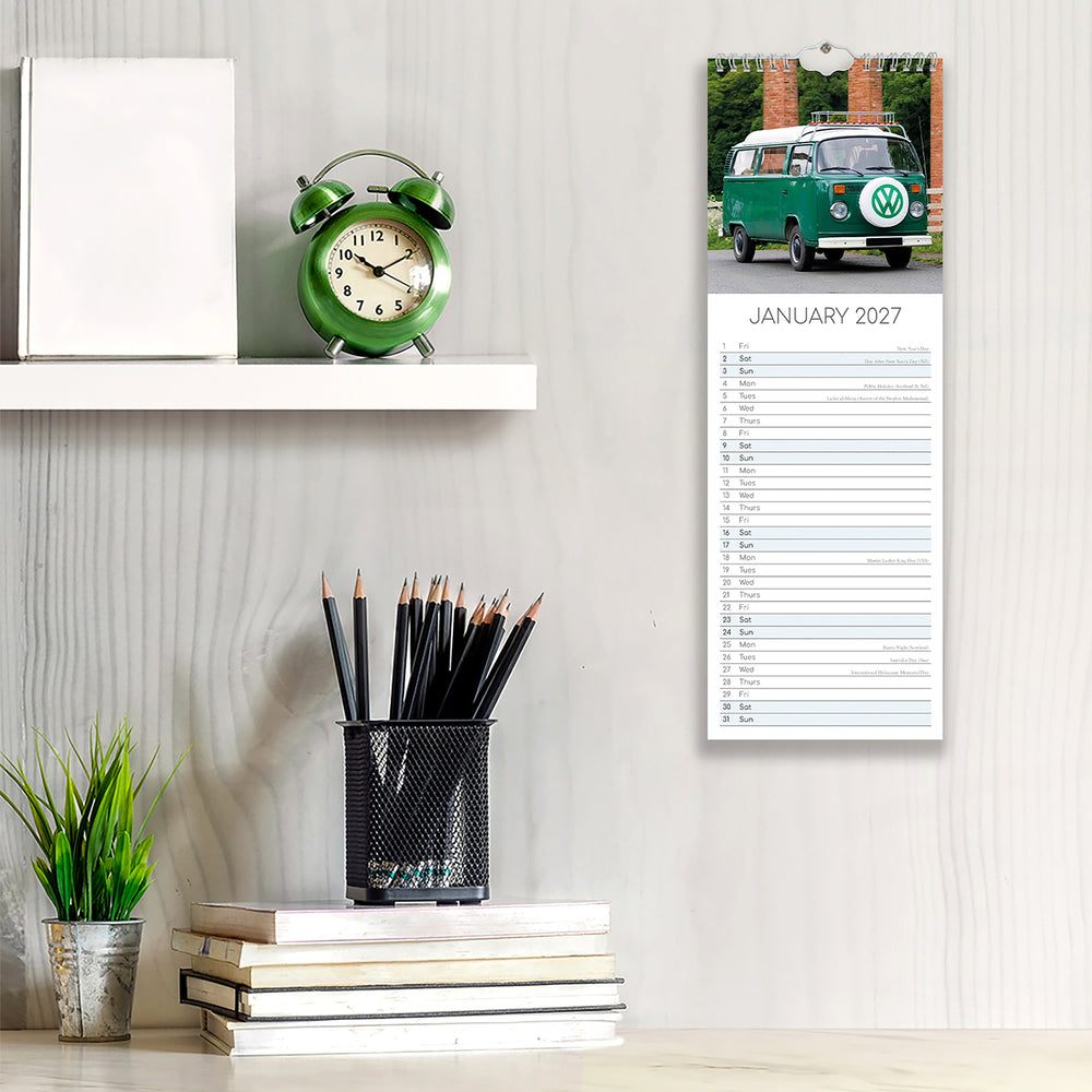 Calendar with a green van design on a wall next to stationery items.