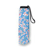 A rolled-up compact umbrella with a blue floral print, featuring white blossoms with pink and yellow centers, a black top cap, and a black wrist strap, shown on a white background.