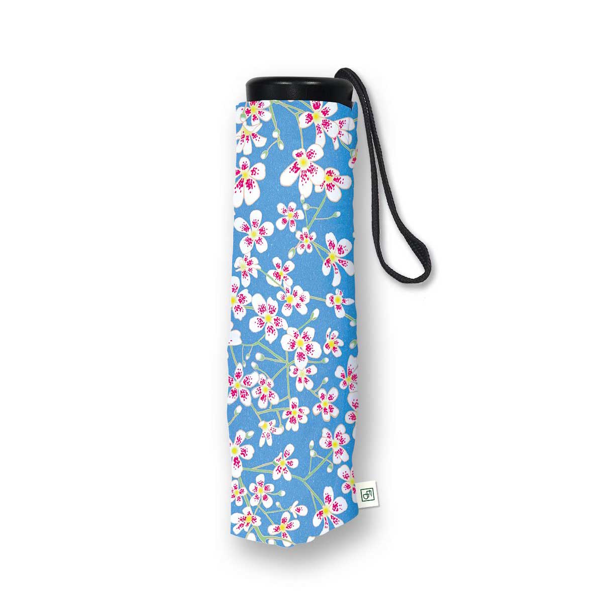 A rolled-up compact umbrella with a blue floral print, featuring white blossoms with pink and yellow centers, a black top cap, and a black wrist strap, shown on a white background.