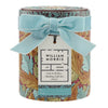 William Morris At Home Bathing Gift Set in a cylindrical tin with a floral pattern, tied with a light blue velvet bow and featuring a white gift tag.