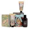 William Morris gift set featuring a bird-patterned box, a floral-patterned hand cream tube, a floral-patterned lotion tube with a light blue ribbon, and a dark amber body wash bottle, all on a white background.