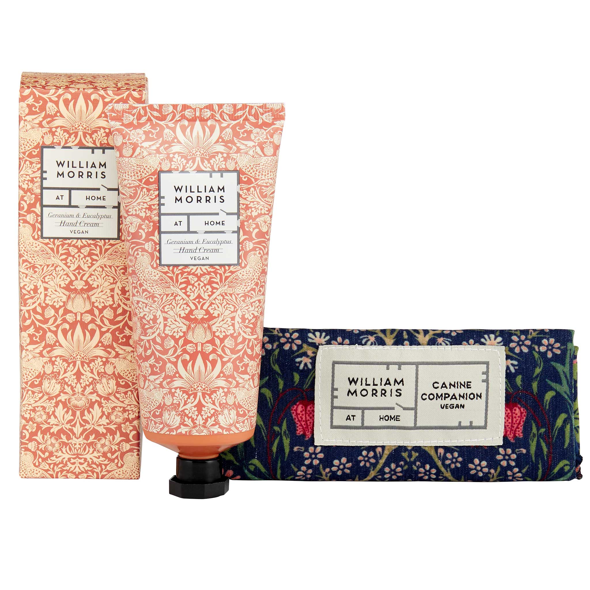 William Morris At Home Cinnamon & Fir Hand Cream set, featuring a patterned squeeze tube, matching box, and a navy blue patterned pet wrap with a white label.