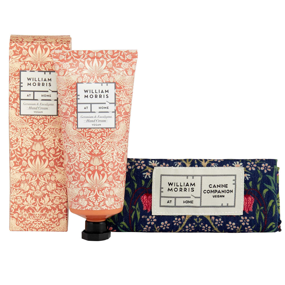 William Morris At Home Cinnamon & Fir Hand Cream set, featuring a patterned squeeze tube, matching box, and a navy blue patterned pet wrap with a white label.