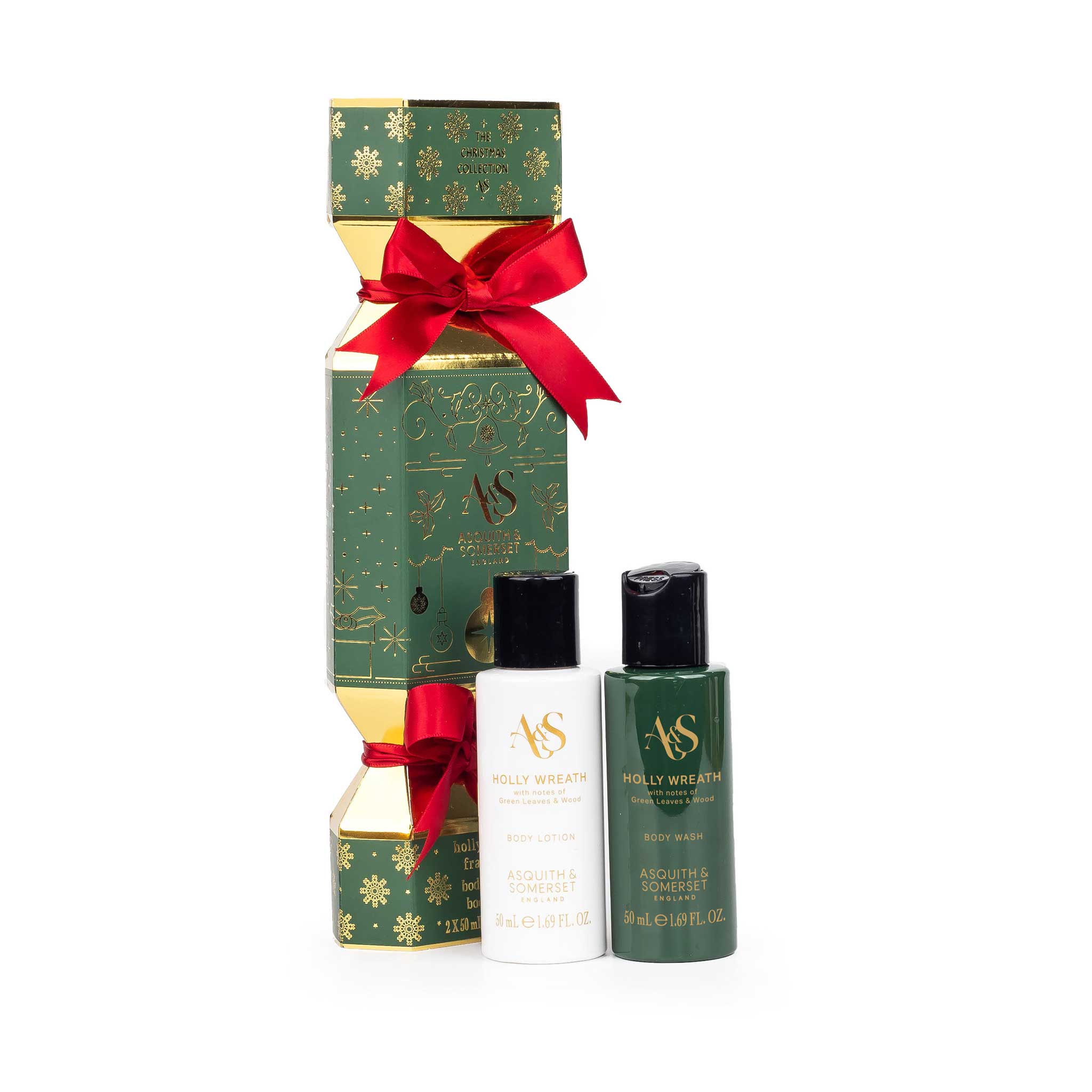 A Christmas-themed gift set from AS Holly wreath, featuring a green and gold box tied with a red ribbon, a small white bottle, and a dark green bottle on a white background.