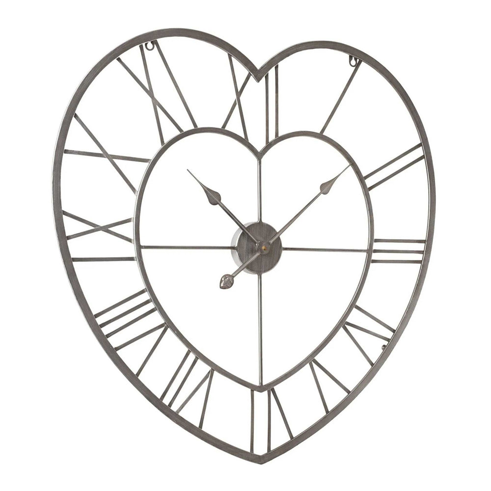 Heart-shaped metal wall clock with an open-frame design, Roman numerals, and decorative hands on a plain white background slightly angled away from camera.