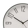 Close-up of a minimalist wall clock face showing the numbers 9, 10, 11, and 12 in a modern cutout style. The clock has a white face with black hands and a black outer rim, with a small gold accent at the center.