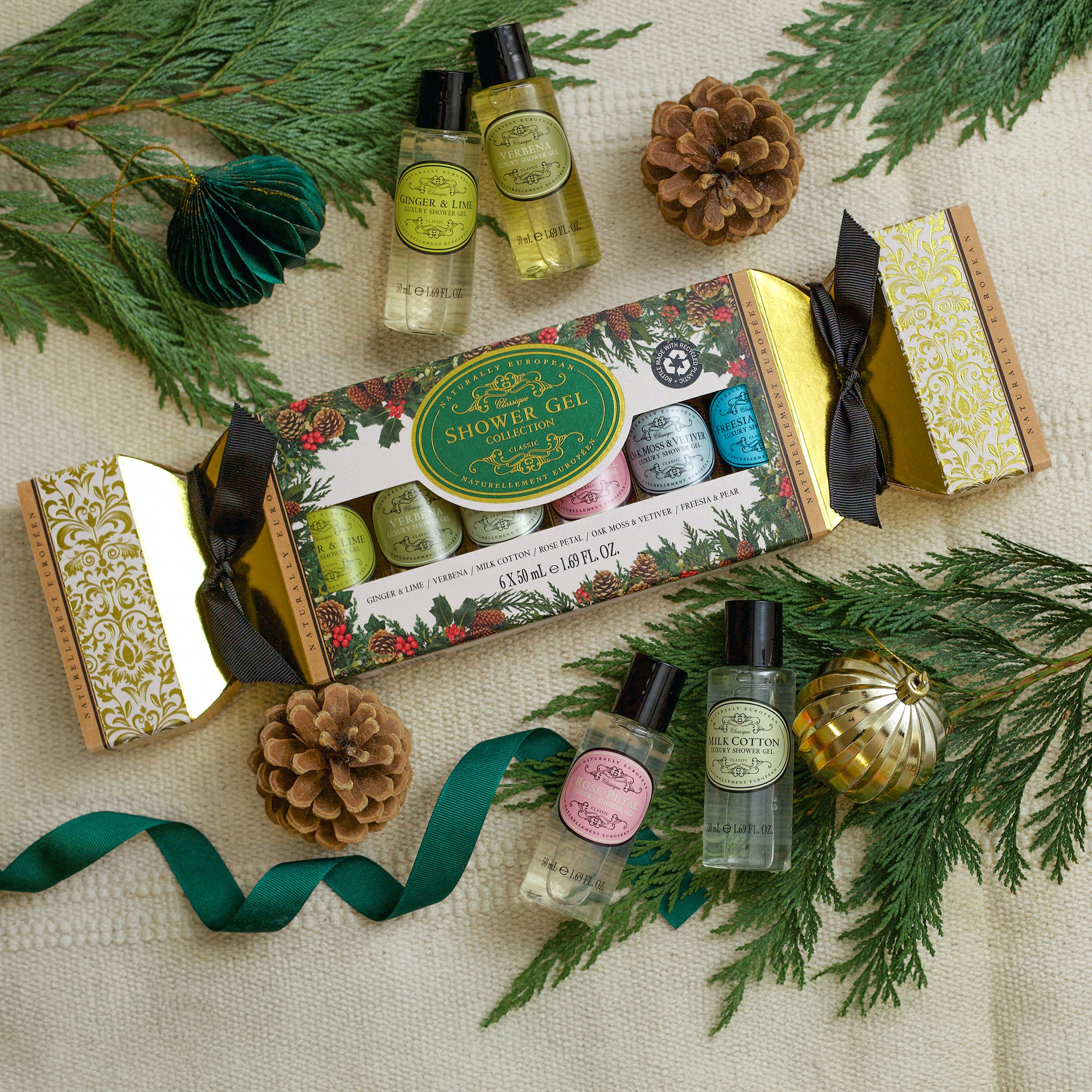 Shower gel set with bottles and packaging on a decorative background with greenery and ribbons.