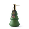Green soap dispenser shaped like a Christmas tree with a gold pump and 'Merry & Bright' tag on a white background.
