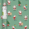 A roll of wrapping paper with a festive repeating pattern of Santa Claus, Christmas trees, and gift boxes on a sage green background. A white paper label is wrapped around the left side of the roll.